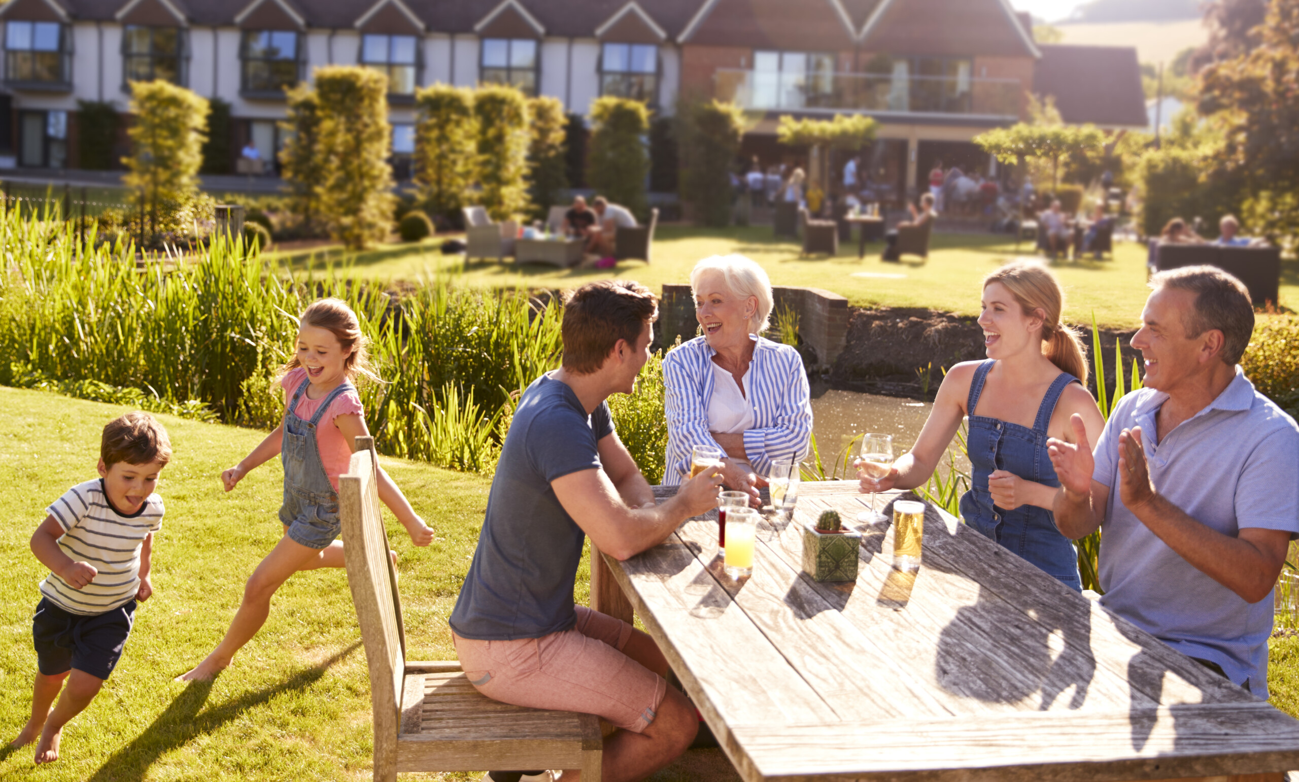 Multi Generation Family Enjoying Outdoor Summer Drink At Pub