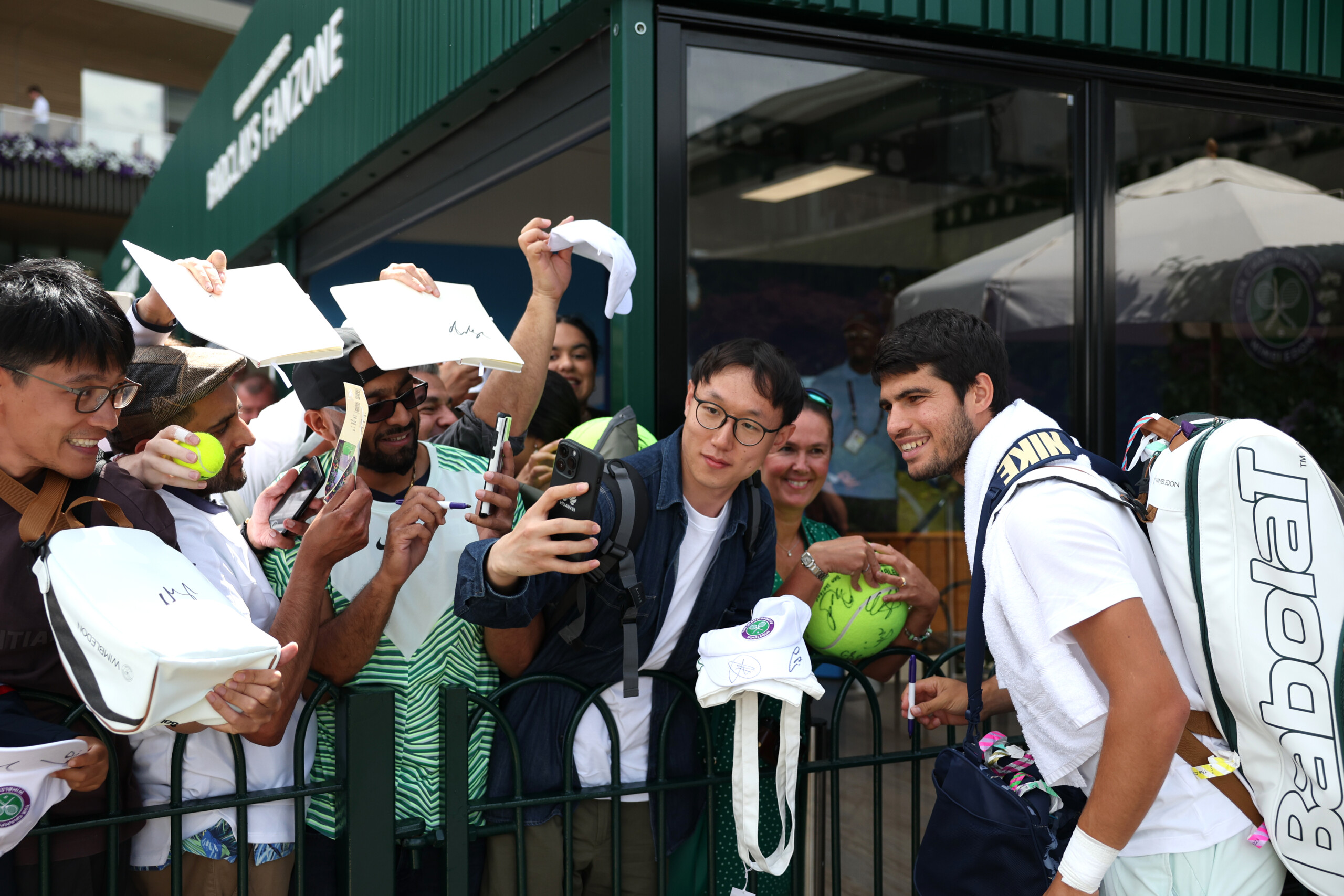 LONDON, ENGLAND - JULY 11: Carlos Alcaraz of Spain takes photos with fans after a training session on day nine of The Championships Wimbledon 2023 at All England Lawn Tennis and Croquet Club on July 11, 2023 in London, England. (Photo by Patrick Smith/Getty Images)