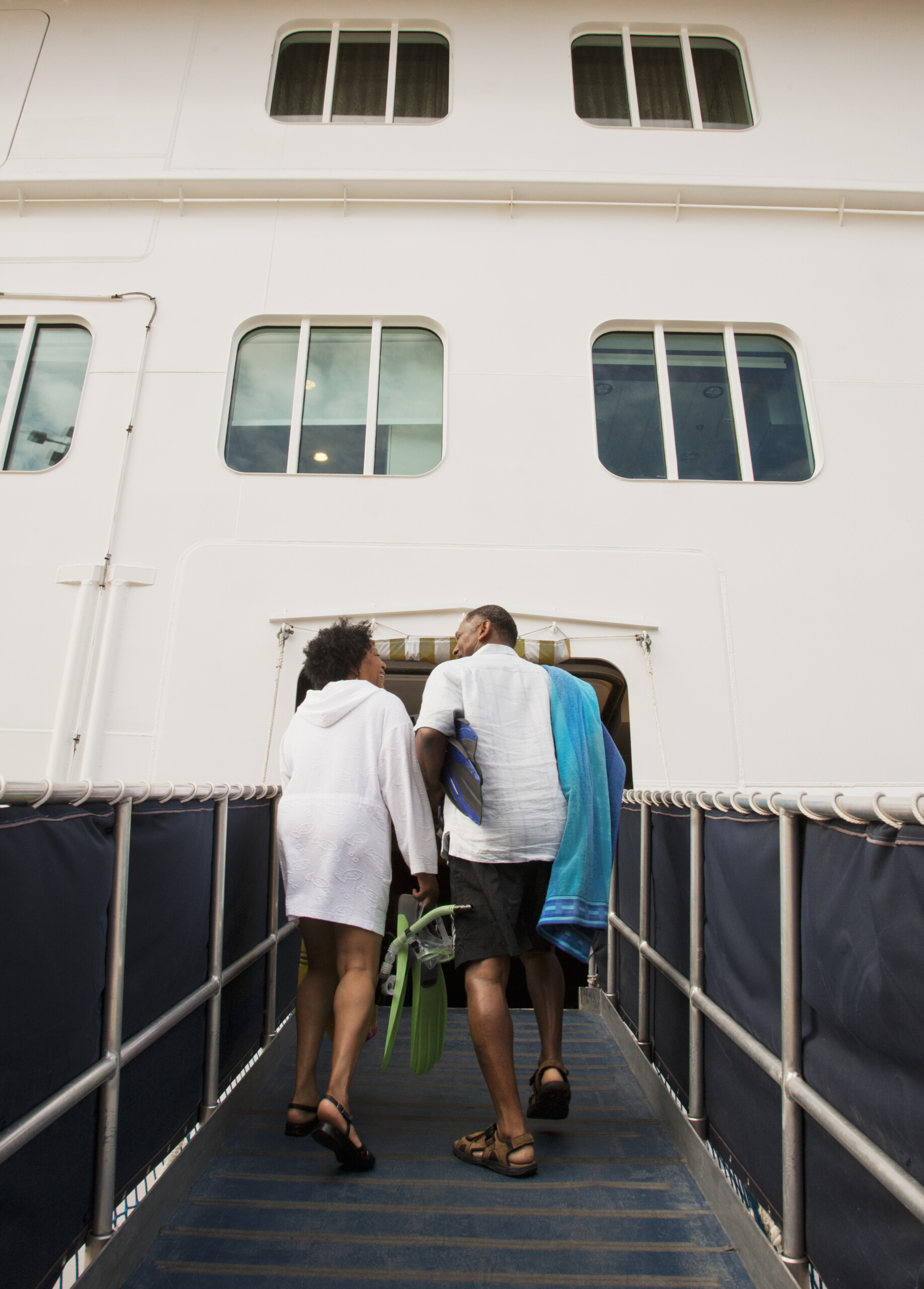 Retired couple entering cruise ship after spending time at their stop