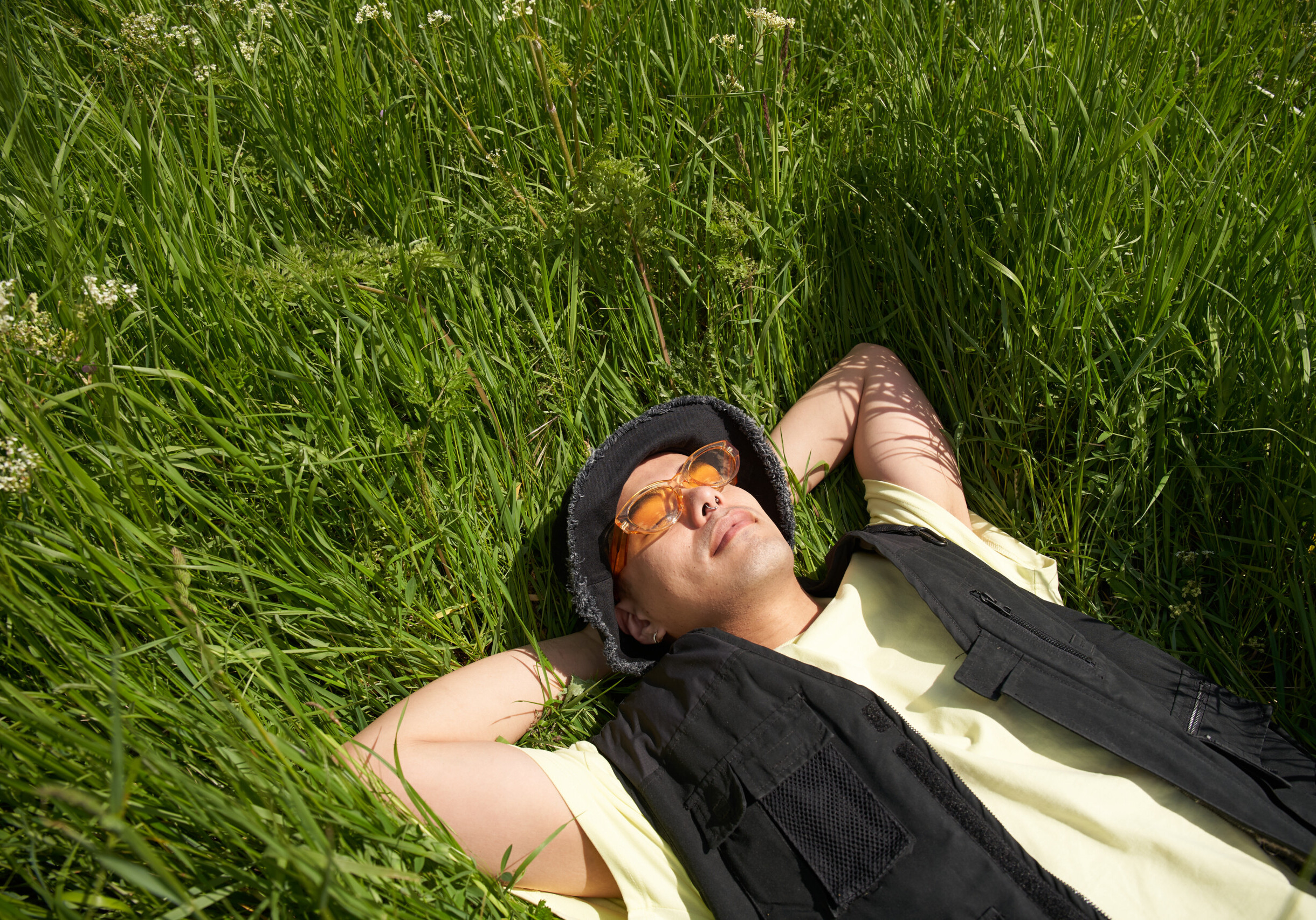 Fashionable man relaxing in long grass on a Spring day