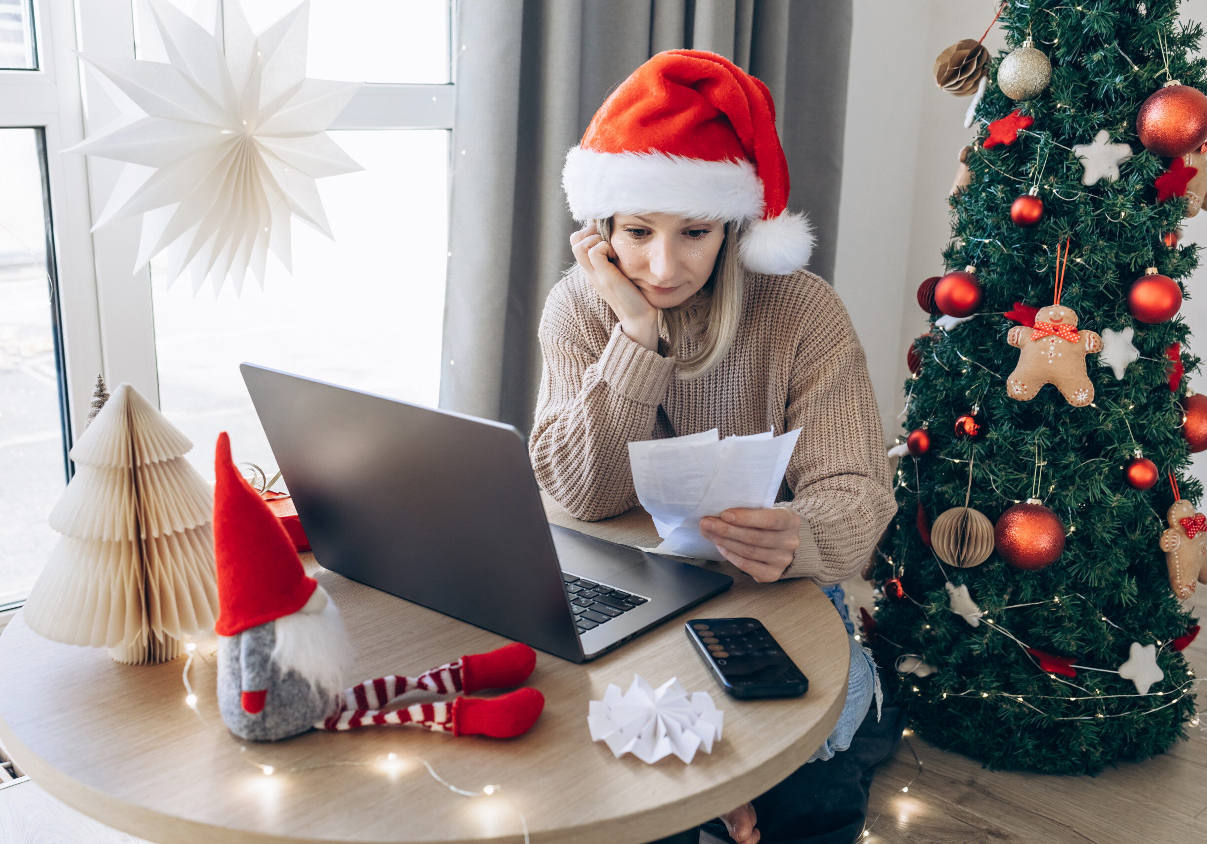 Woman Reviewing bills and checks at Festive Home Workspace. Preparing to Christmas Holidays