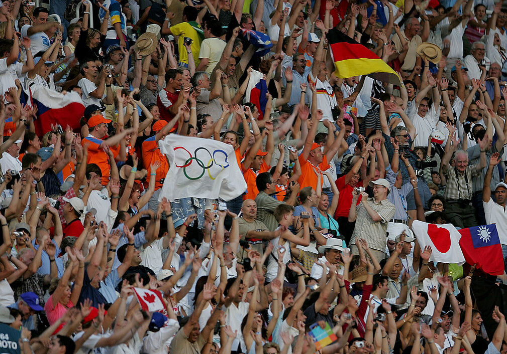 ATHENS - AUGUST 13: Spectators wave flags during the opening ceremony of the Athens 2004 Summer Olympic Games on August 13, 2004 at the Sports Complex Olympic Stadium in Athens, Greece. (Photo by Robert Laberge/Getty Images)